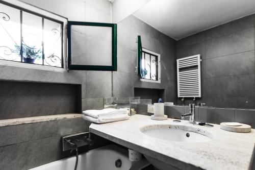 ein Badezimmer mit einem Waschbecken und zwei Fenstern in der Unterkunft MilanRentals - Ripa Apartment in Mailand