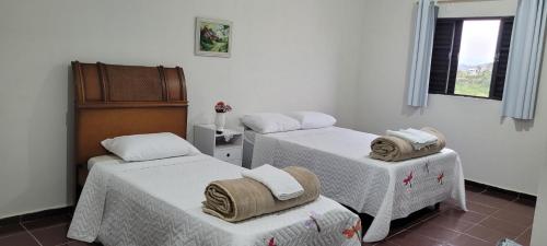 a room with two beds with towels on them at Kit net amplo in São Lourenço