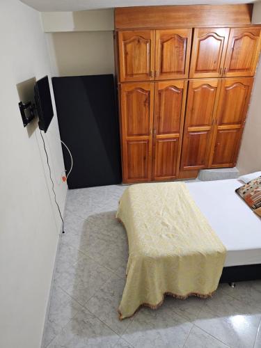 a room with a bed with wooden cabinets at Guadalupe ApartaHotel Calle 9 5-66 Apartamento 102 in Jardin