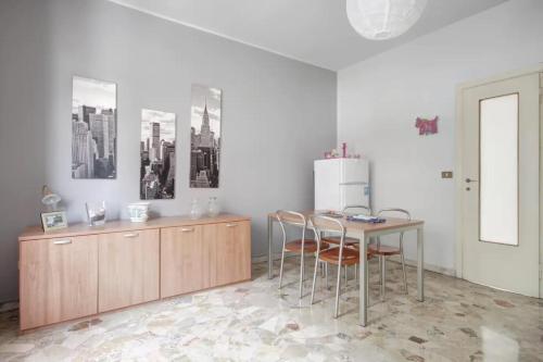 cocina con mesa, sillas y nevera en MilanRentals - Lotto Apartment, en Milán