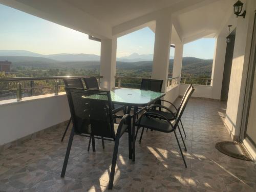 a table and chairs on a balcony with a view at Villa with mountain view in Gevgelija
