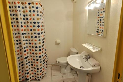 uma casa de banho com um WC, um lavatório e uma cortina de chuveiro em Appart Suites Citadines Access 15 minutes Paris Montparnasse - Metro & Accès facile Paris Parc Expo em Châtillon