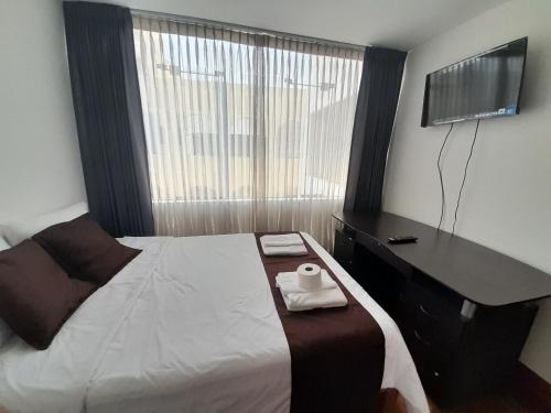 - une chambre avec un lit et une commode avec une serviette dans l'établissement Habitacion doble, à Arequipa