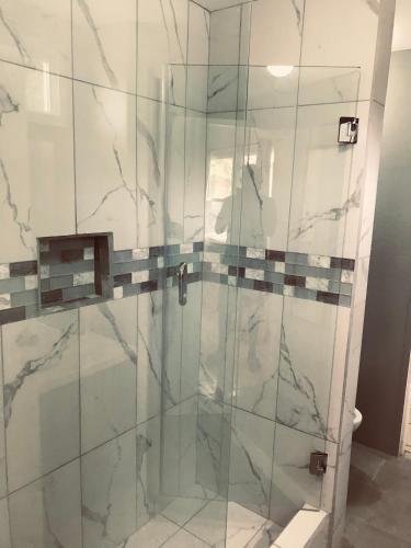 a bathroom with a shower with a glass door at HCEAS villa is 5 min fr. airport & to the beaches in Bon Accord