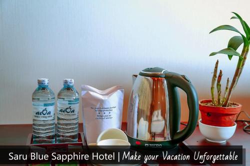 uma mesa com uma chaleira e 2 garrafas de água em Saru Blue Sapphire Hotel em Godakewela