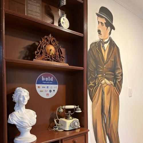 a statue of a man in a top hat and a clock on a shelf at HOSTAL SEP7IMO ARTE in Bogotá