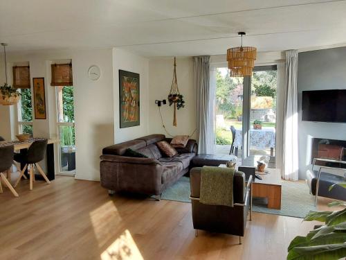 a living room with a couch and a table at Rumah Senang Wellness met hottub en tuin in Ewijk
