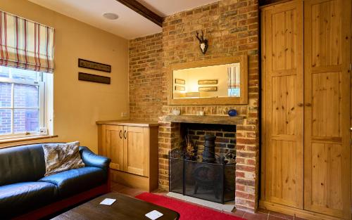 a living room with a brick fireplace and a couch at Nature Charm & Fruit Delights, multi-generation celebratory home -Try, Relax, Repeat - Sellindge in Ashford