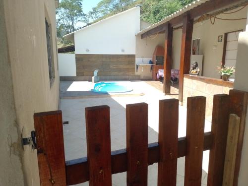 een uitzicht op een patio via een houten hek bij Casa de temporada in Resende