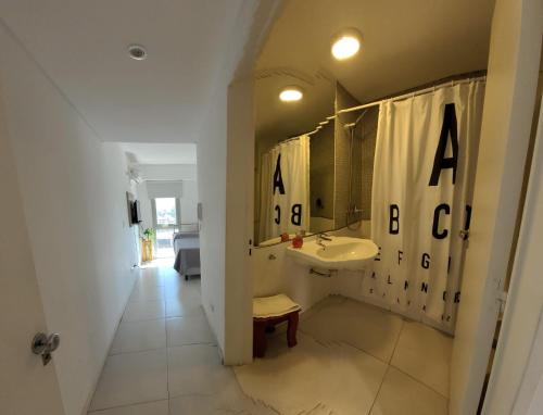 a bathroom with a sink and a shower curtain with the alphabet at Monoambiente con cochera en Puerto Norte in Rosario