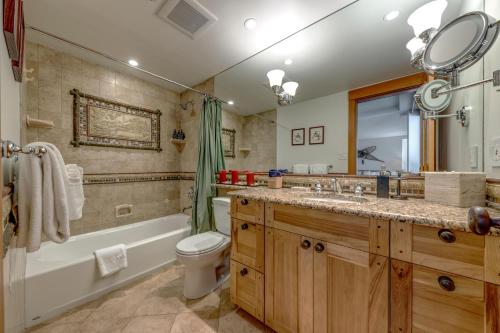 een badkamer met een bad, een toilet en een wastafel bij Woodrun 208 - Ski In Ski Out, Common Area Hot Tub & Pool, Fireplace in Whistler