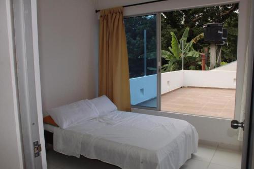 a bedroom with a bed and a large window at Finca Palma Roja in Villavicencio