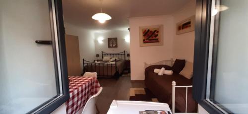 un piccolo soggiorno con divano e letto di Casa das Matriarcas - Casa da Avó Elisinha a Belmonte