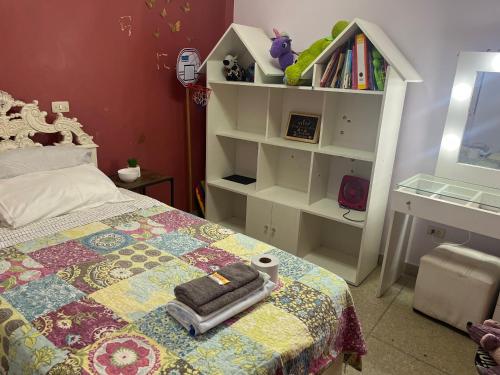 1 dormitorio con cama y estante para libros en Alójate en una Casa familiar, en Barranca