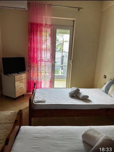 1 Schlafzimmer mit 2 Betten, einem TV und einem Fenster in der Unterkunft Villa Castle View in Shkodra