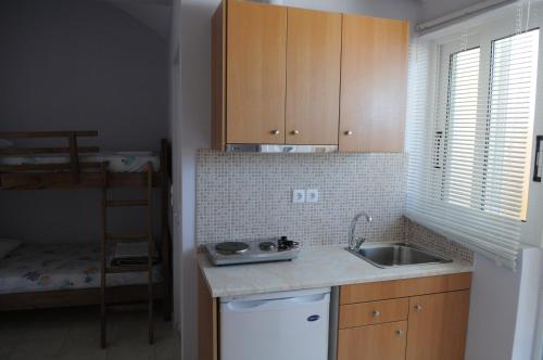 a small kitchen with a sink and a bunk bed at Olympion Village Studios in Zakharo