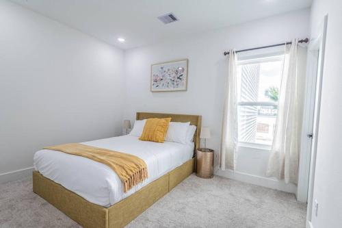 ein weißes Schlafzimmer mit einem Bett und einem Fenster in der Unterkunft Luxury Home Near DTW/ Med Ctr in Houston