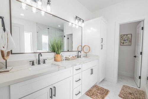 ein weißes Badezimmer mit 2 Waschbecken und einem großen Spiegel in der Unterkunft Luxury Home Near DTW/ Med Ctr in Houston