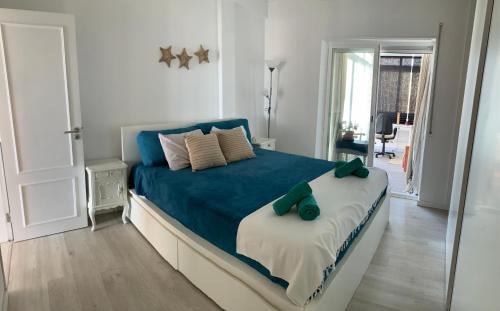 um quarto com uma cama azul e um espelho em Sun & Sea rooftop em Costa da Caparica