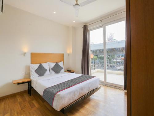 a bedroom with a large bed and a large window at Super Townhouse 080 Meera Bagh in New Delhi