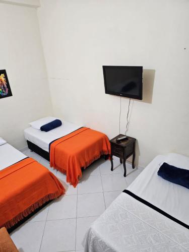 a room with two beds and a flat screen tv at GUADALUPE 102 in El Charquito