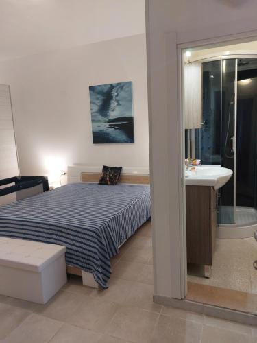 een slaapkamer met een bed, een wastafel en een spiegel bij La Sebastiana in Porto Torres