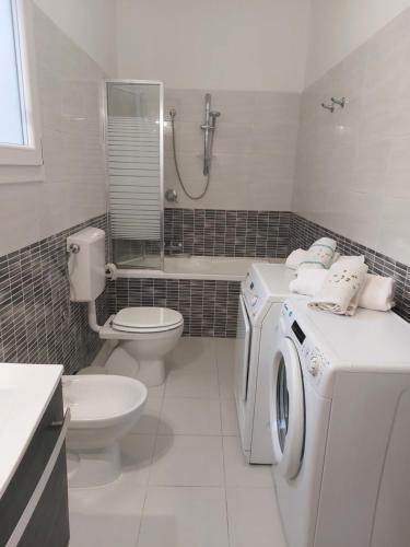een badkamer met een wasmachine en een toilet bij La Sebastiana in Porto Torres
