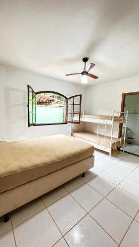 1 dormitorio con 1 cama y ventilador de techo en CASA VERDE en Ubatuba