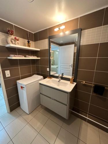une salle de bain avec un lavabo, des toilettes et un miroir dans l'établissement Cosy 2 pièces à 1min à pied de la plage et proximité de la gare de train, à Juan-les-Pins