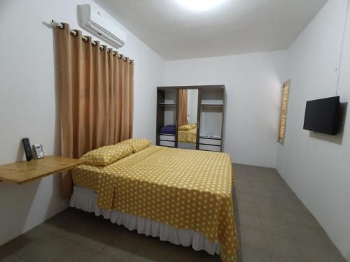 - une chambre avec un lit doté d'une couverture jaune polka dans l'établissement Bom pra ficar, à Limoeiro do Norte