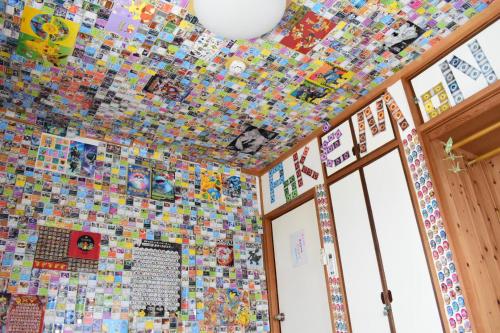 um quarto com uma parede coberta de azulejos lego em OMOLOSO Hostel　オモロソウ ホステル em Beppu