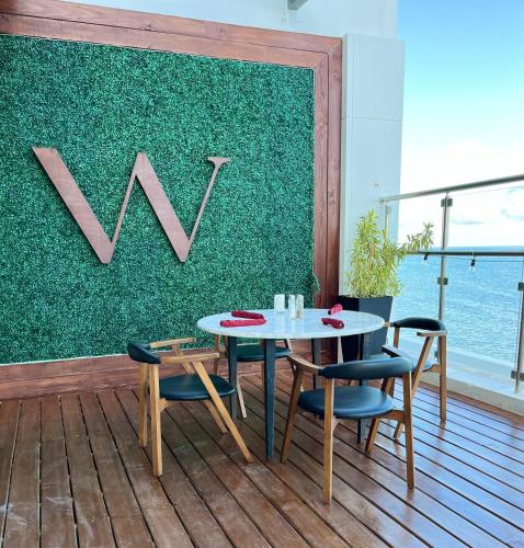 a table and chairs on a deck with a green wall at The Watermark Hotel in San Pedro