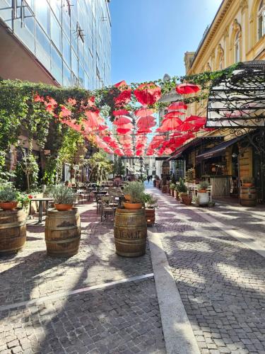 a street with tables and chairs and red umbrellas at Booking Apartment Rajiceva in Belgrade