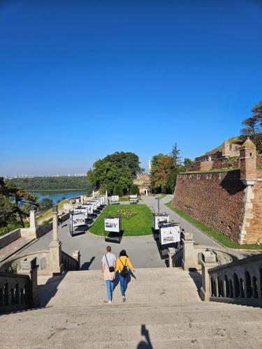 two people walking down the stairs of a castle at Booking Apartment Rajiceva in Belgrade