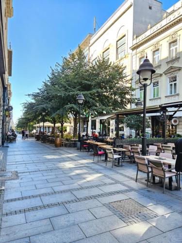 an empty street with tables and chairs and buildings at Booking Apartment Rajiceva in Belgrade