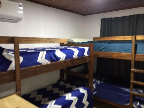 een slaapkamer met 2 stapelbedden met blauwe lakens bij Alojamiento La Mamu 2 in Paso de la Patria