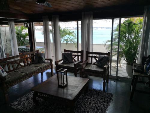 a living room with chairs and a coffee table and the ocean at Coco Beach Apart 3A in Natal