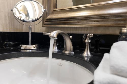 a bathroom sink with water running from a faucet at Lucky Gem Penthouse & Luxury Suites at Signature Resort, Balcony Strip View 1607 in Las Vegas