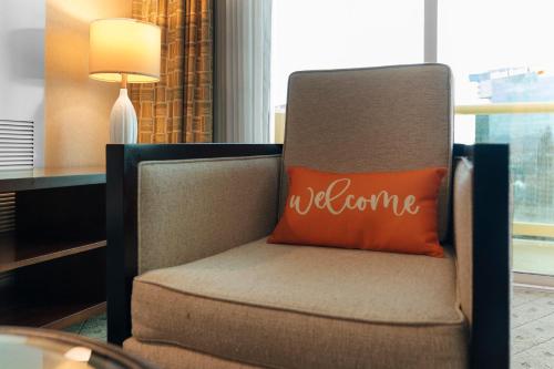 a chair with a pillow that says welcome at Lucky Gem Penthouse & Luxury Suites at Signature Resort, Balcony Strip View 1607 in Las Vegas