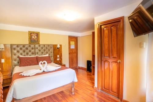 a bedroom with a bed with two swans on it at Santuario Machupicchu in Machu Picchu