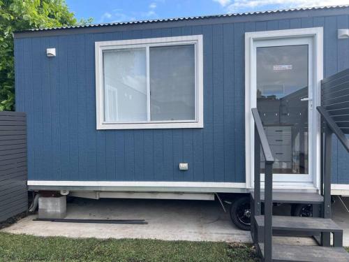 una casetta blu piccola con finestra e rampa di Sweet Cute blue tiny home with Pool and 2 minute drive to the beach a Wollongong