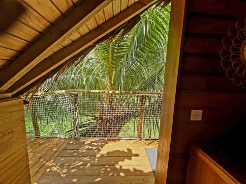 an open door to a screened in porch with a palm tree at Pura vida Lodge in Sainte-Rose