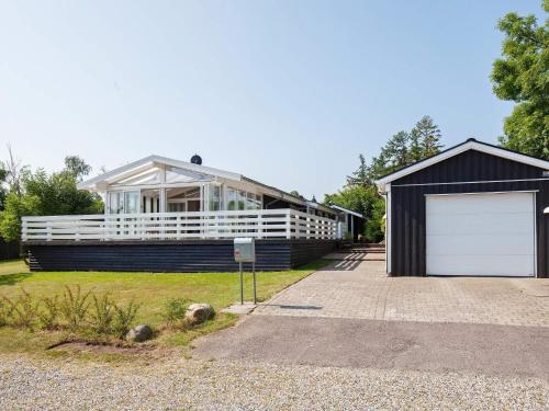 una casa grande con un garaje delante en 6 person holiday home in Str by en Køge