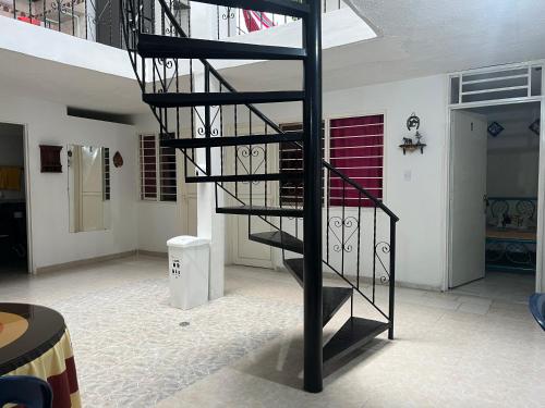a black spiral staircase in the middle of a room at Helena Hostel in Cali