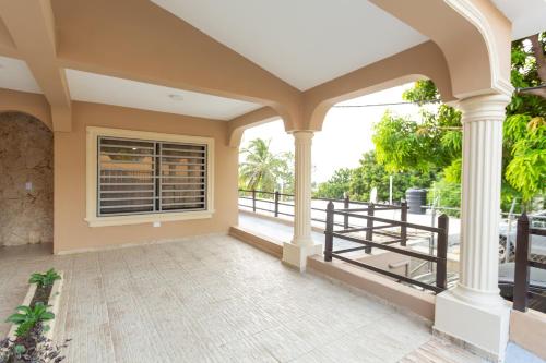 a large porch with columns and a window at MB Apartment - B in San Felipe de Puerto Plata