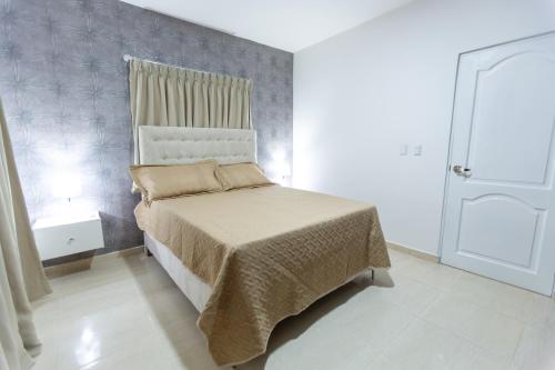 a small bedroom with a bed and a window at MB Apartment - B in San Felipe de Puerto Plata