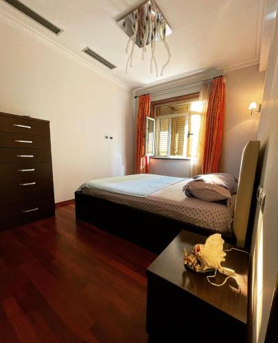 een slaapkamer met een bed en een dressoir bij Edjon Apartments in Tirana