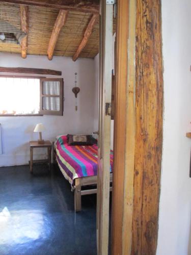 a bedroom with a bed in a room with a window at La Calabaza Cabaña in Tilcara