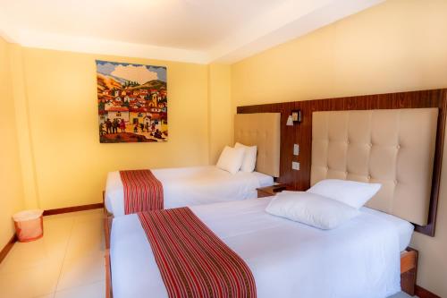 a hotel room with two beds and a painting on the wall at Santuario Machupicchu in Machu Picchu