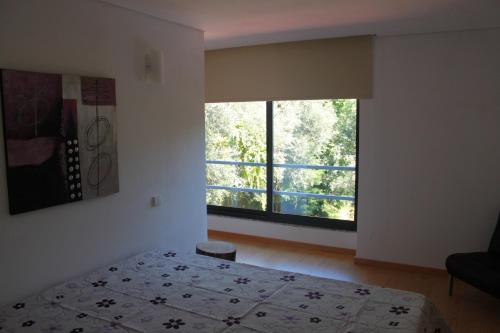 a bedroom with a bed and a large window at Casas do Corvo in Ventosa